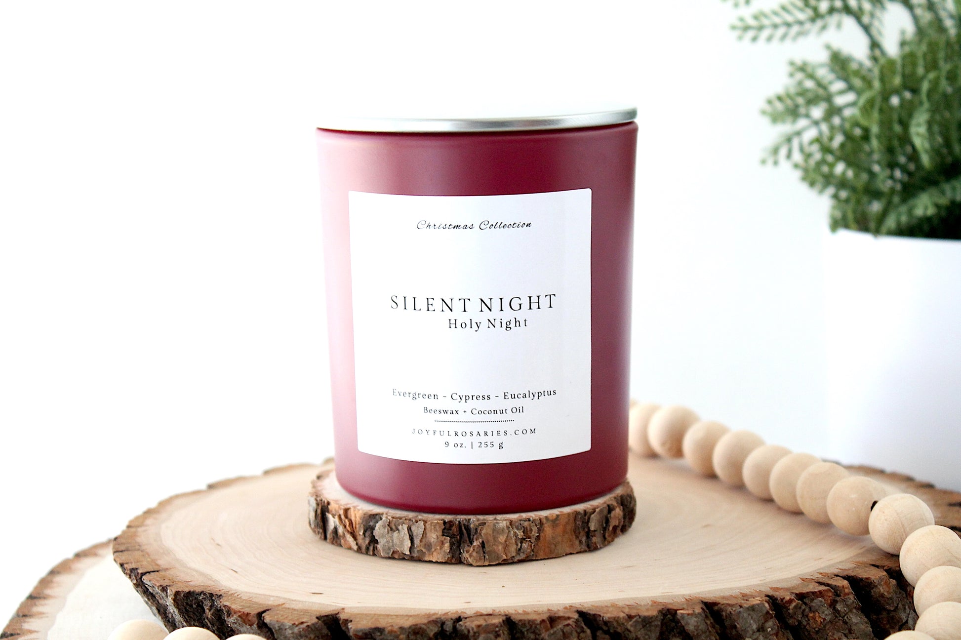 Candle labeled 'Silent Night' on a wooden surface with a white background