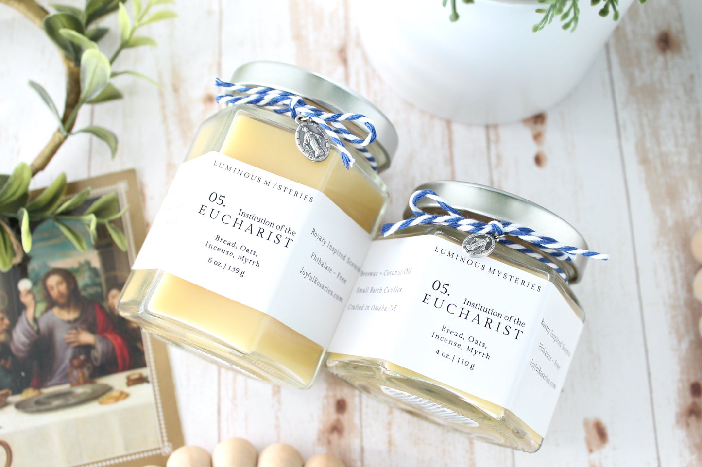 Two jars labeled 'Eucharist' on a wooden surface with a blurred background