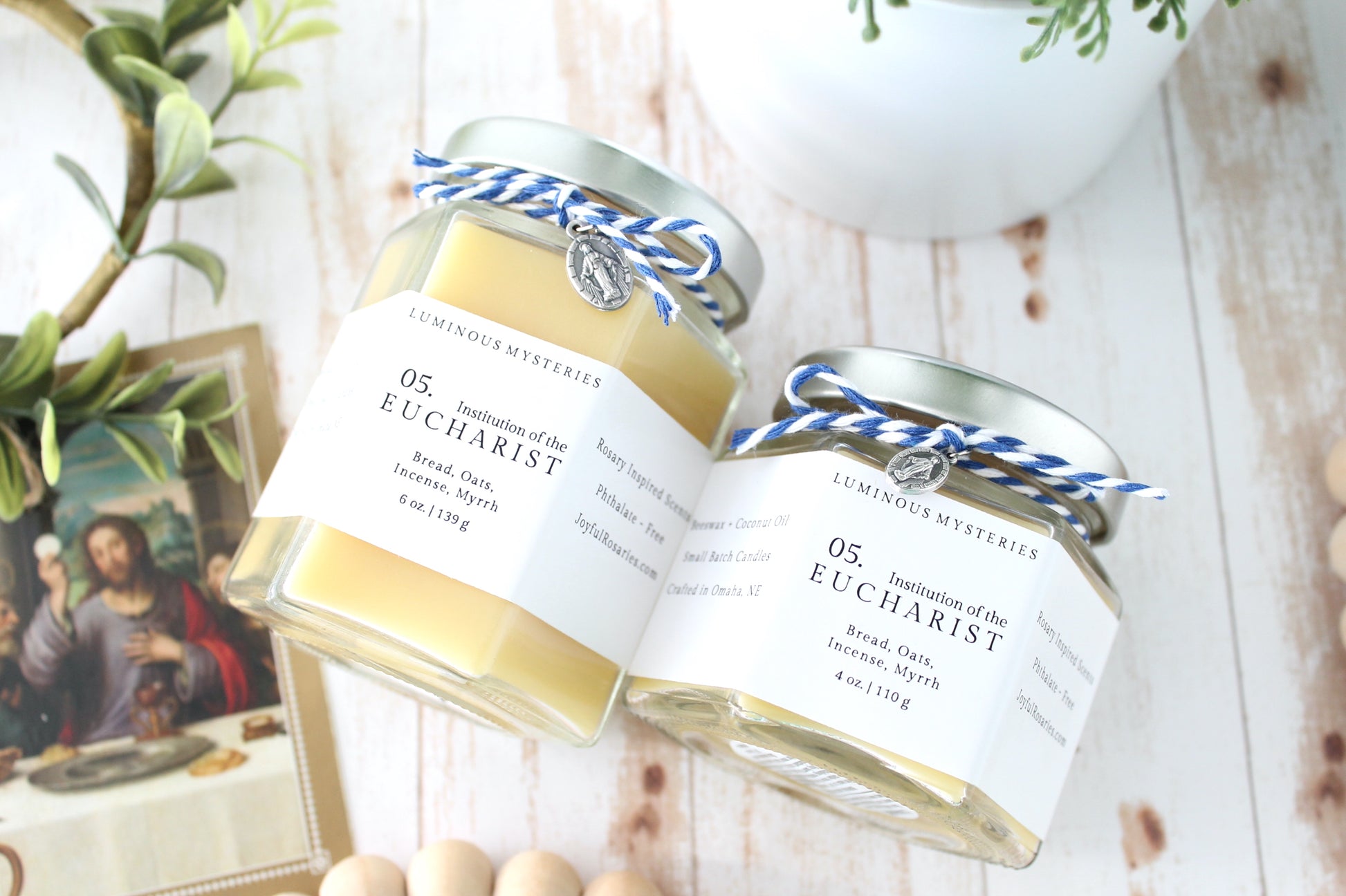 Two jars labeled 'Eucharist' on a wooden surface with a blurred background