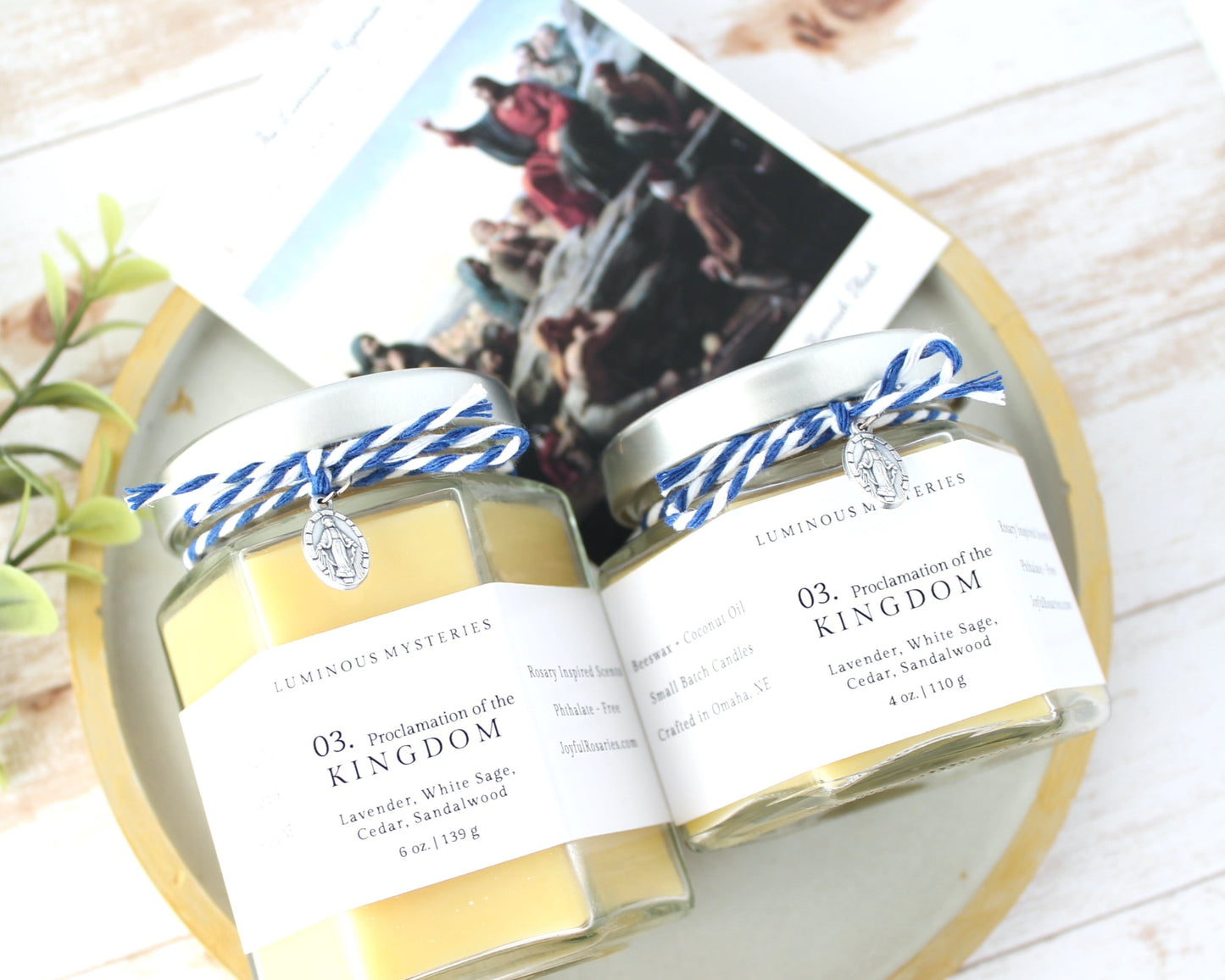 Two jars of 'Kingdom' body butter on a wooden surface with a magazine underneath.