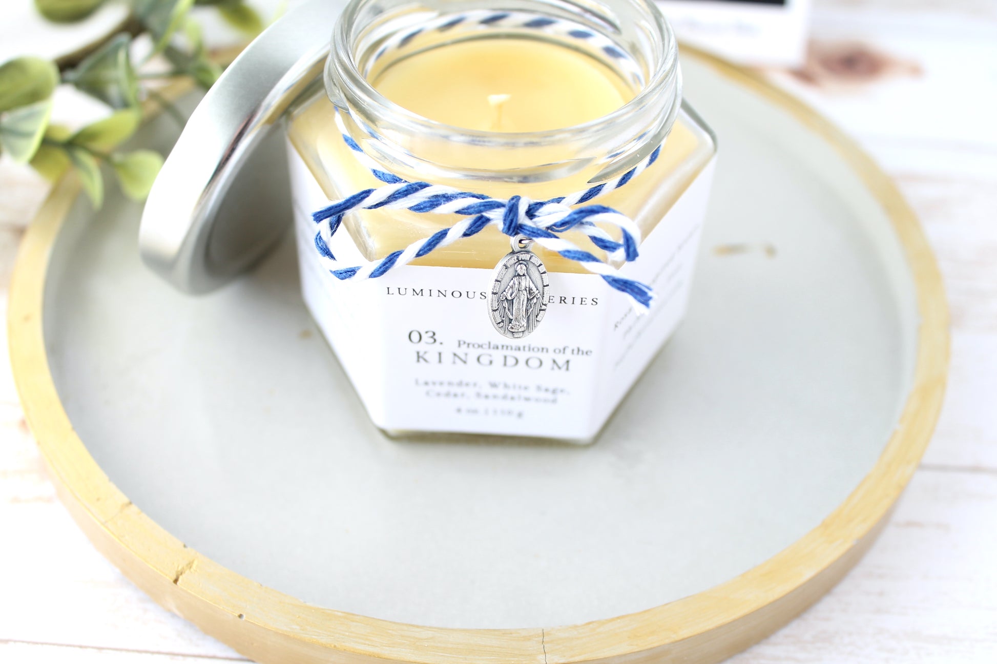 Jar of candle with decorative label on a white surface