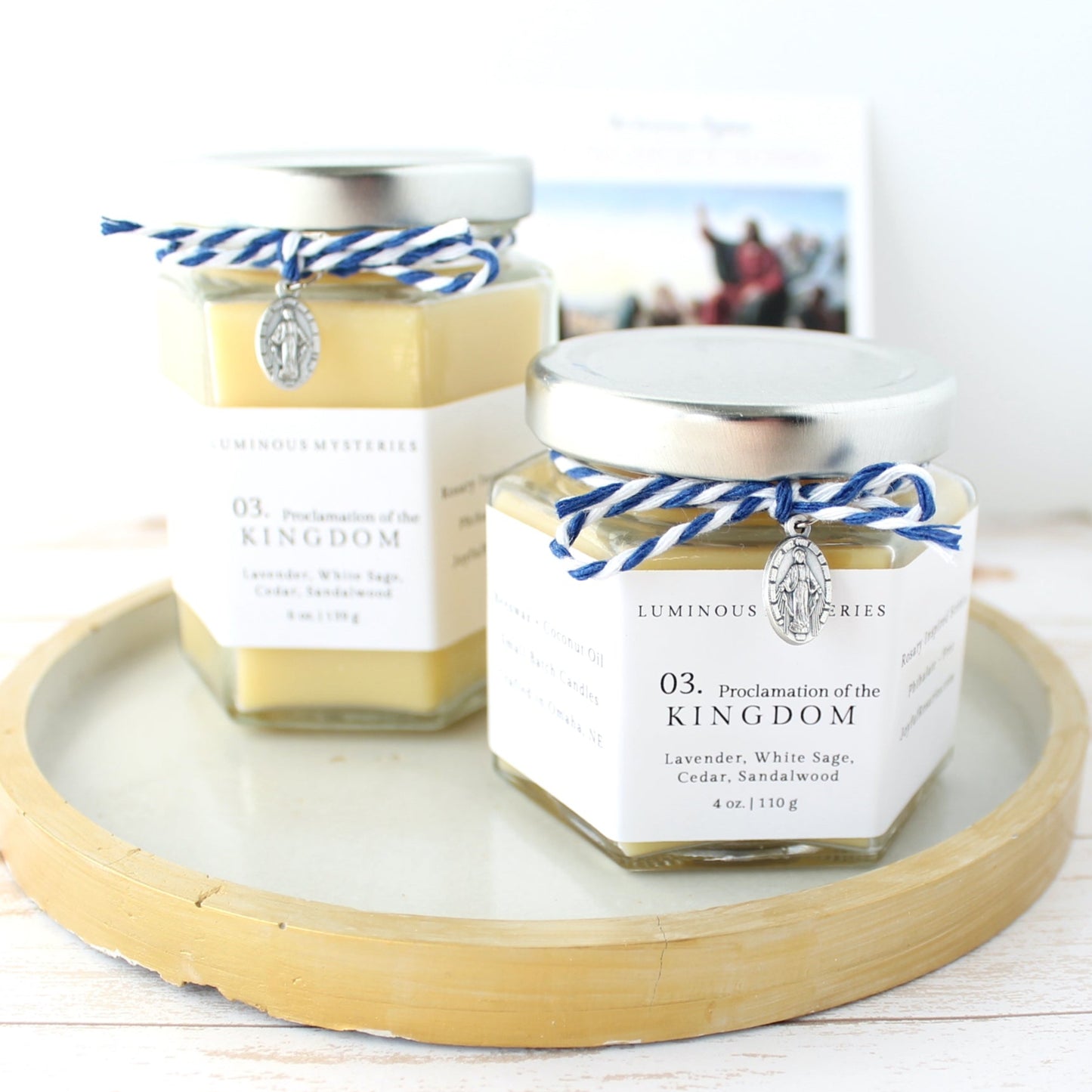 Two hexagonal jars with labels on a wooden tray against a white background