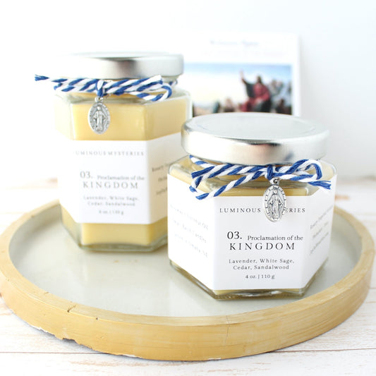 Two hexagonal jars with labels on a wooden tray against a white background
