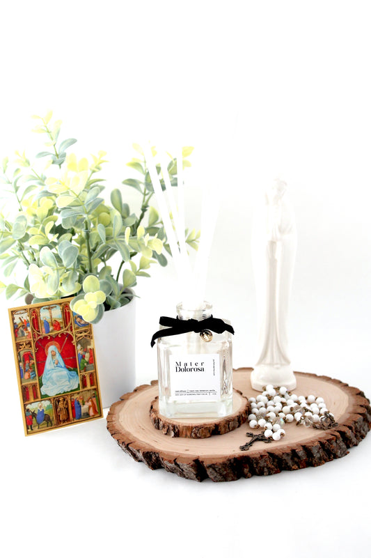 reed diffuser bottle with holy card and rosary